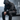 Goblin Gear Acid Wash Hoodie – person wearing a dark hoodie with a logo, sitting on a bench in a blurred indoor setting